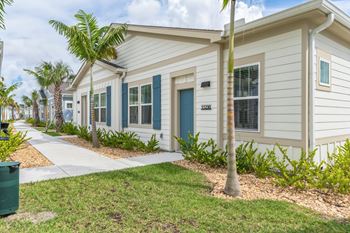 A row of houses with blue doors and windows. at The Boardwalk at Tradition, Port St Lucie, Florida